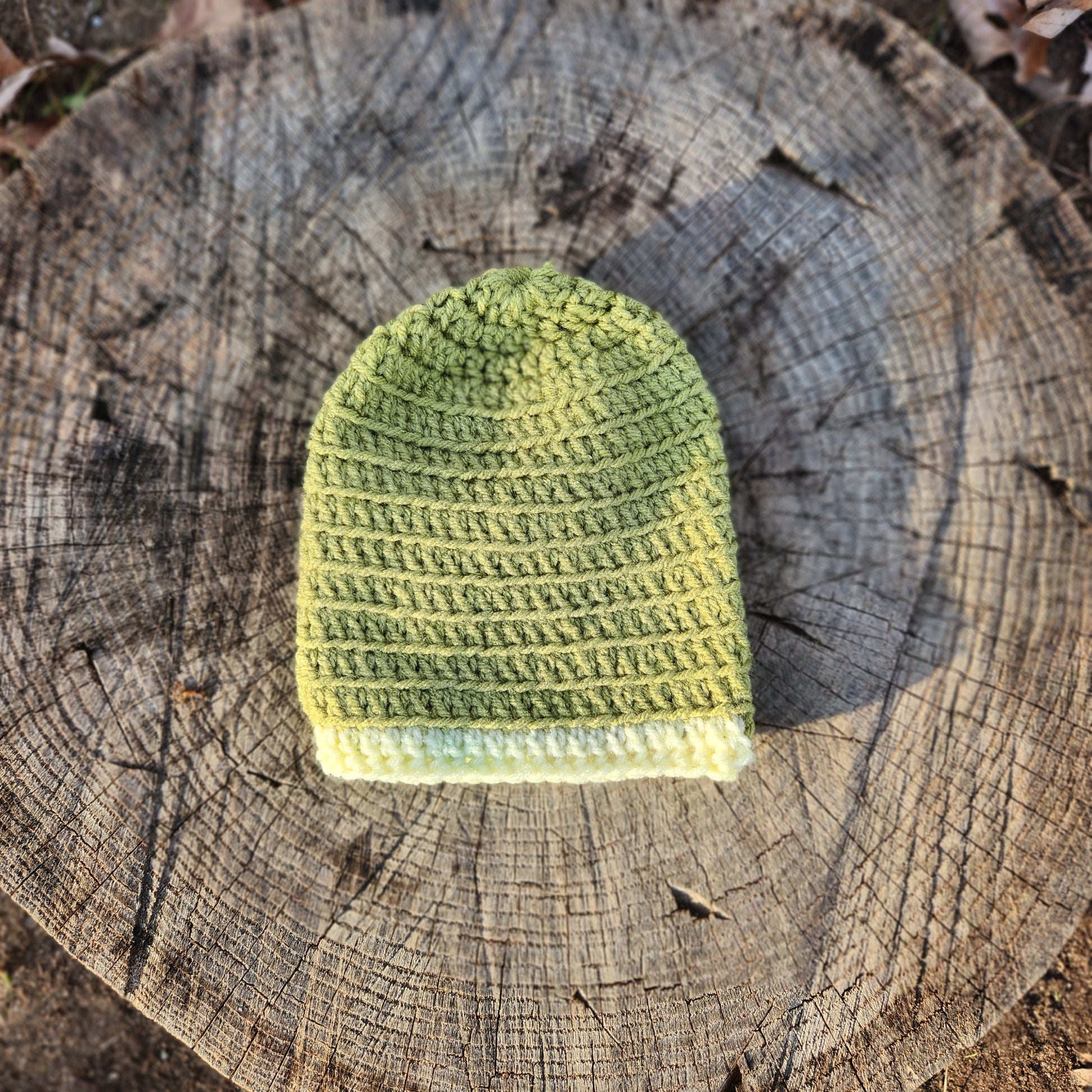 Olive green crochet baby hat with pale yellow trim